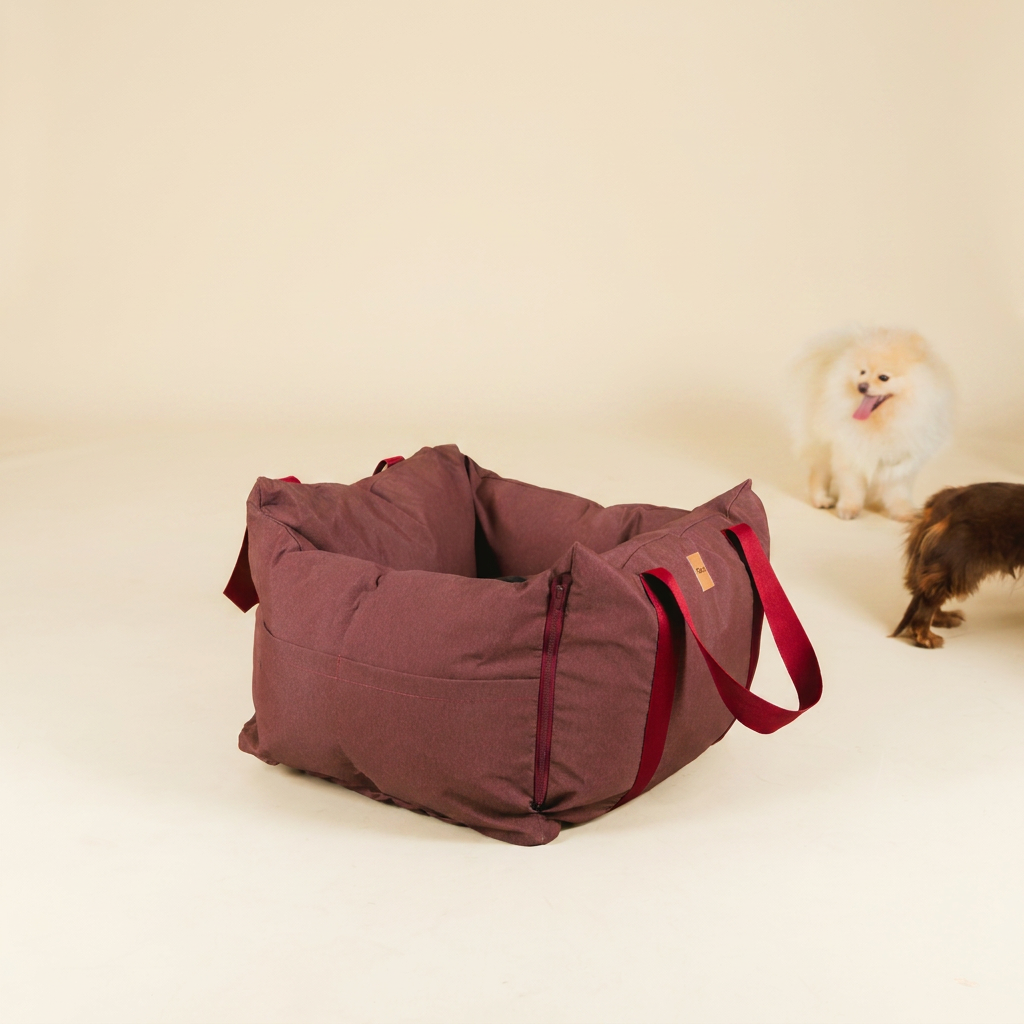 Bolsa de Transporte Cangú Explora Amora vazia em três quartos, com dois cachorros ao fundo